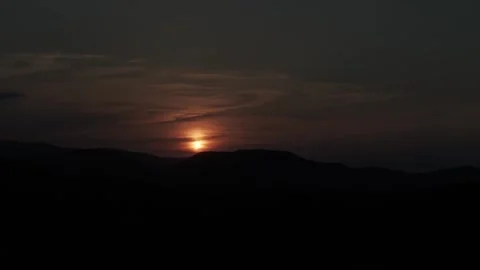Partial Solar Eclipse Casting Shadows Over Hills at Dusk Stock Footage 344441089
