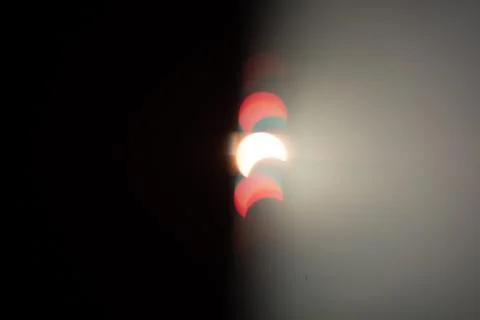 Partial solar eclipse with colorful flares and sun flare in the sky Fotos Stock