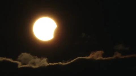 Partial solar eclipse glows in a dark sky as the Moon obscures part of the Sun. Vídeos de archivo 342743309