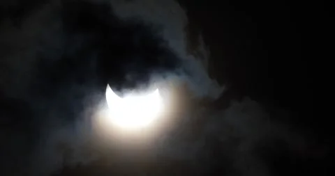 A partial solar eclipse seen through clouds Stock Footage 281707142