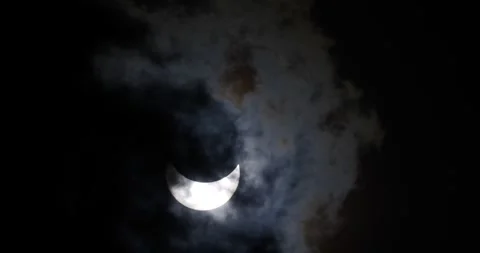 A partial solar eclipse seen through clouds Stock Footage 281707172