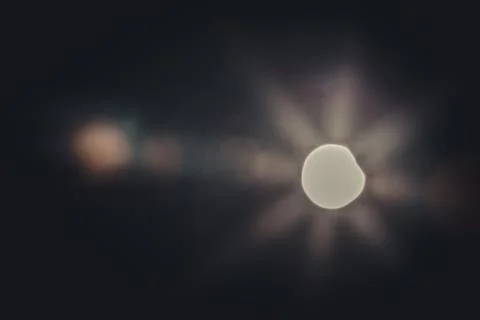 A partial solar eclipse in the sky over Latvia with rays piercing through clouds Stock Photos
