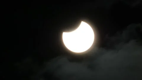 Partial Solar Eclipse With a Small Thin Layer of Clouds Moving Past the Stock Footage 219907752