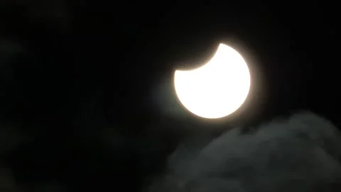 Partial Solar Eclipse With a Small Thin Layer of Clouds Moving Across the Stock Footage 219907943