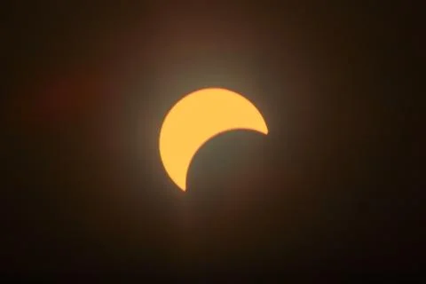 Partial Solar Eclipse with Sun's Crescent in Warm Skies Stock Photos