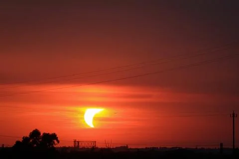 Partial solar eclipse at sunset over Rome skyline with Gasometer silhouette. Stock Photos