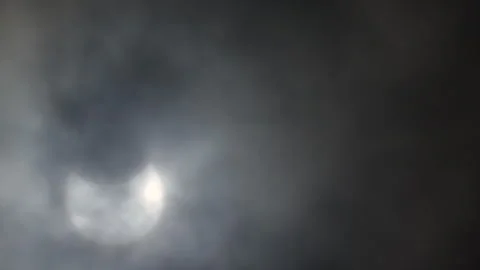 Partial solar eclipse through cloud, UK, 29th March 2025 Stock Footage 305309697