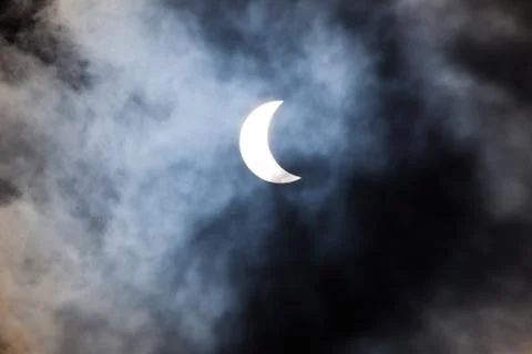 Partial solar eclipse through clouds Fotos Stock