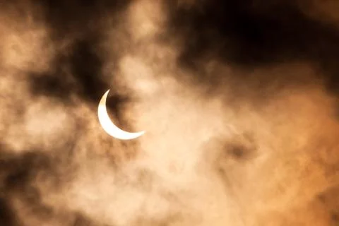 Partial solar eclipse through clouds Fotos Stock