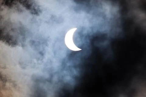Partial solar eclipse through clouds Fotos Stock