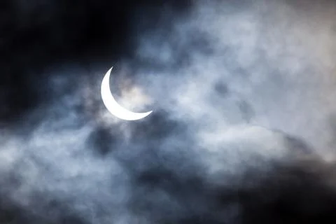 Partial solar eclipse through clouds Fotos Stock