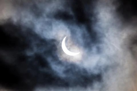 Partial solar eclipse through clouds Fotos Stock