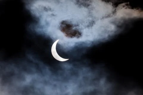 Partial solar eclipse through clouds Fotos Stock