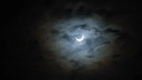 Partial solar eclipse through a cloudy sky on Oct 10 2023 Stock Footage 253005068