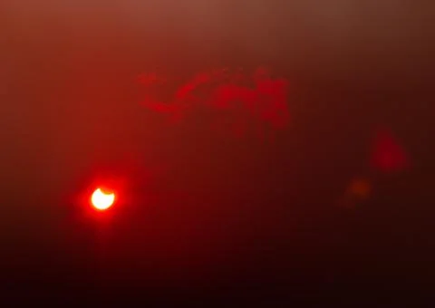 A partial solar eclipse through floppy tape and thin clouds Stock Photos