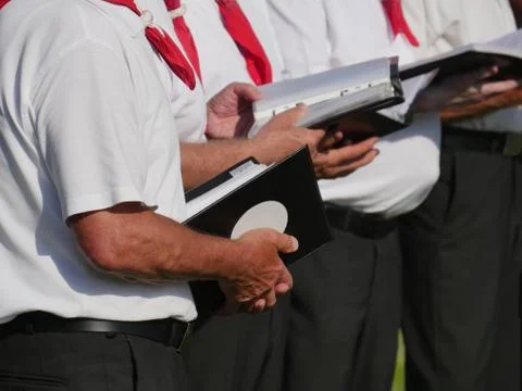 Partial view of 3 singers of a choir, holding in their hands textbooks, Stock Photos