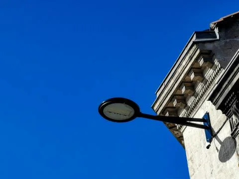 Partial view of an ancient typical building and fixed modern street light wit Stock Photos