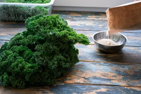 Partial view of chef pouring sesame seeds on a small bowl set on styling colo Stock Photos