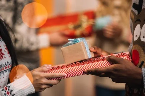 Partial view of couple exchanging gifts while celebrating christmas together Fotos Stock