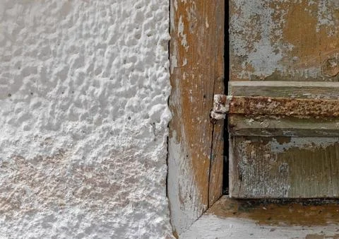 Partial view of old weathered window shutters on white washed wall Stock Photos
