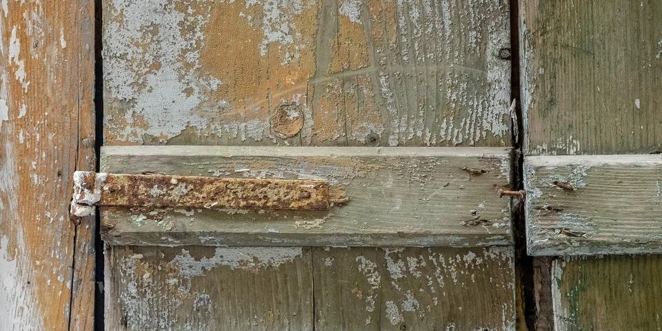 A partial view of old weathered window shutters and rusty hinges Stock Photos