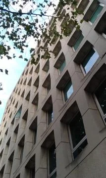 Partial view of a stone office building façade with gridal window texture. 스톡 사진