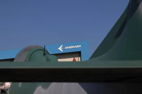 Partial view of a Supertucano plane in the foreground with the Embraer factory Stock Photos