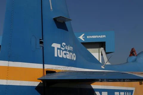 Partial view of a Supertucano plane in the foreground with the Embraer factory Stock Photos
