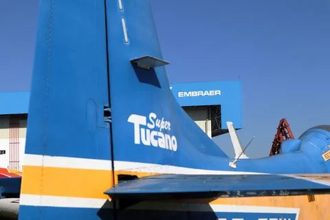 Partial view of a Supertucano plane in the foreground with the Embraer factory Stock Photos