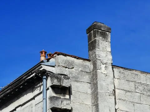 Partial view of a typical ancient house with chimney against blue sky Stock Photos