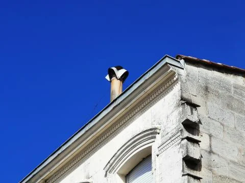Partial view of a typical ancient house with chimney against blue sky Stock Photos