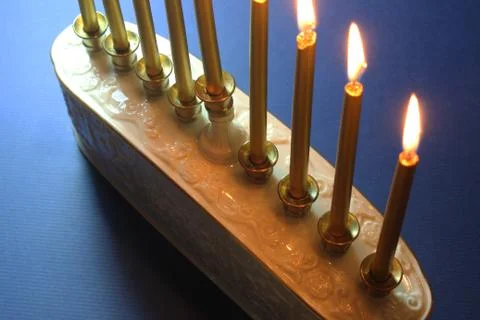 Partial view of a white ceramic menorah with gold candles Stock Photos
