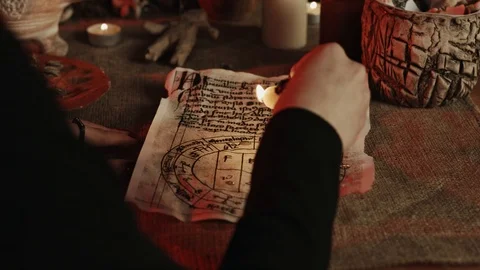 Partial view of witch dripping wax on pentagram during occult ritual Stock Footage 125838835