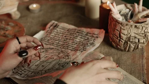 Partial view of witch putting needle in voodoo doll while practicing black magic Stock Footage 125023434