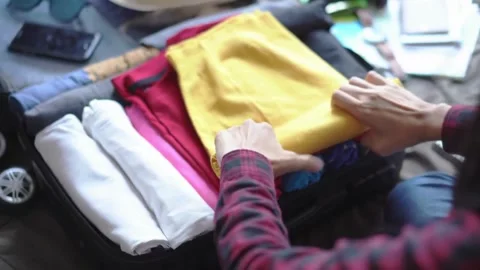 Partial view of woman packing suitcase with summer clothes on floor at home Vídeos de archivo 336235837