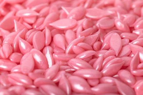Partially blurred, selective focus hot film wax granules for depilation close Foto stock