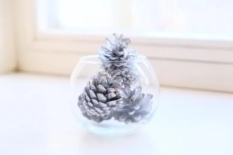 Partially blurred view with low sharpness transparent vase with silver cones 스톡 사진