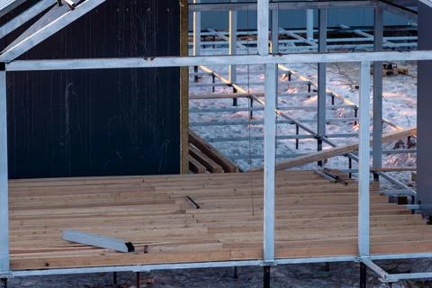 A partially built house. Metal?frame structure with wooden flooring rising .. 库存照片