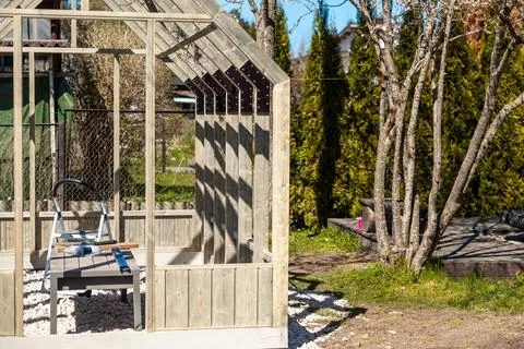 Partially Built Timber Greenhouse Frame with Tools and Step Ladder Stock Photos