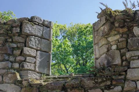 A partially collapsed window in an old stone monastery Stock Photos