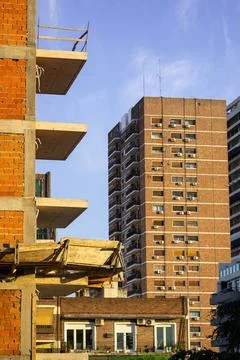 A partially constructed brick building with exposed concrete balconies Stock Photos