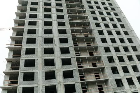 A partially constructed concrete building with multiple floors and empty wind Stock Photos
