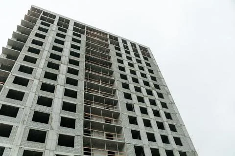 A partially constructed concrete building with multiple floors and empty wind Stock Photos