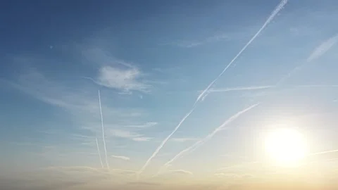 Partially dissipating jet trails over blue atmosphere Stock Footage 347525337
