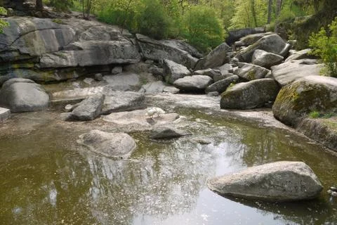 Partially dried up forest brook between large stones. On one of them there ar Stock Photos
