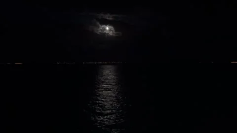 Partially eclipsed moon with clouds at night over the sea. Stock Footage 316894829