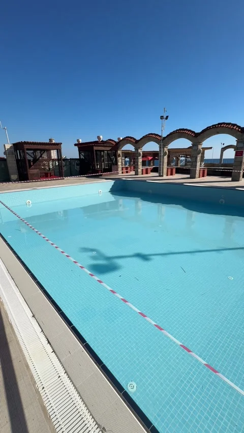 Partially empty resort pool at the end of the tourist season, being closed fo 스톡 동영상 310851525