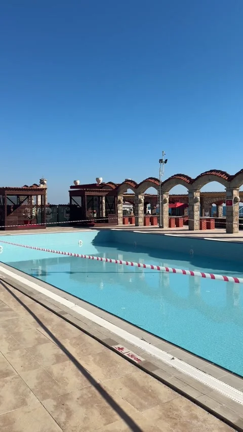 Partially empty resort pool at the end of the tourist season, being closed fo Video stock 310851560