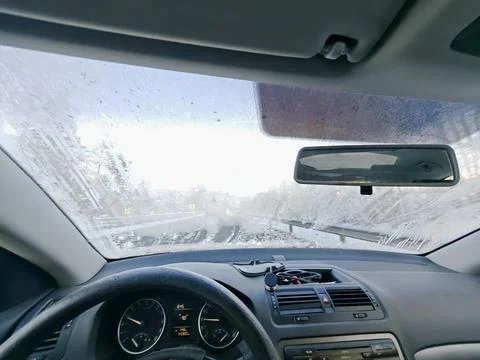 Partially frozen car windshield viewed from the vehicle interior, closer view Stock Photos