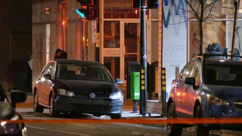 Partially hidden cops and suspect in the street at night with parked cars Stock Footage 100178673